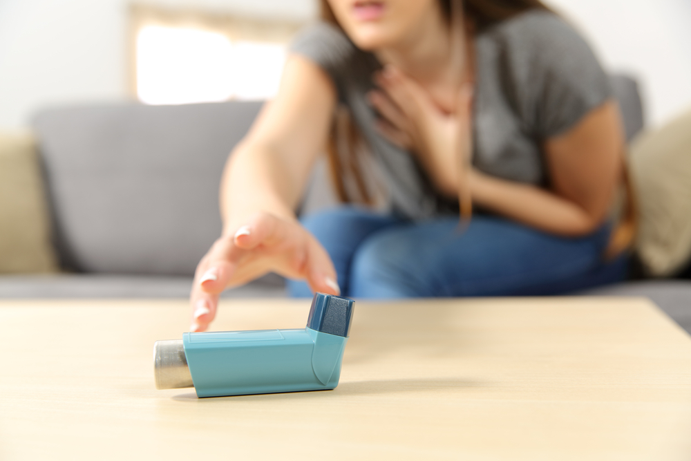 Girl,Suffering,Asthma,Attack,Reaching,Inhaler,Sitting,On,A,Couch