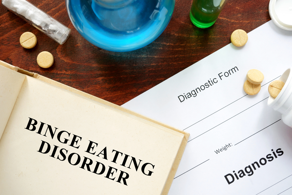 Binge,Eating,Disorder,Written,On,Book,With,Tablets.,Medicine,Concept.