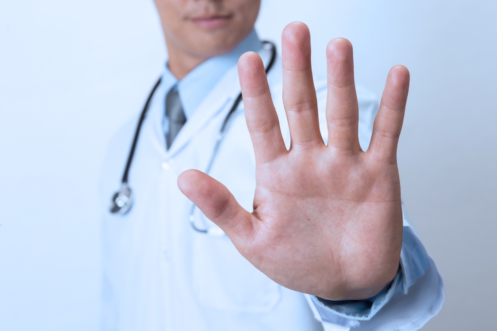 Doctor,Showing,Stop,Sign,On,White,Background