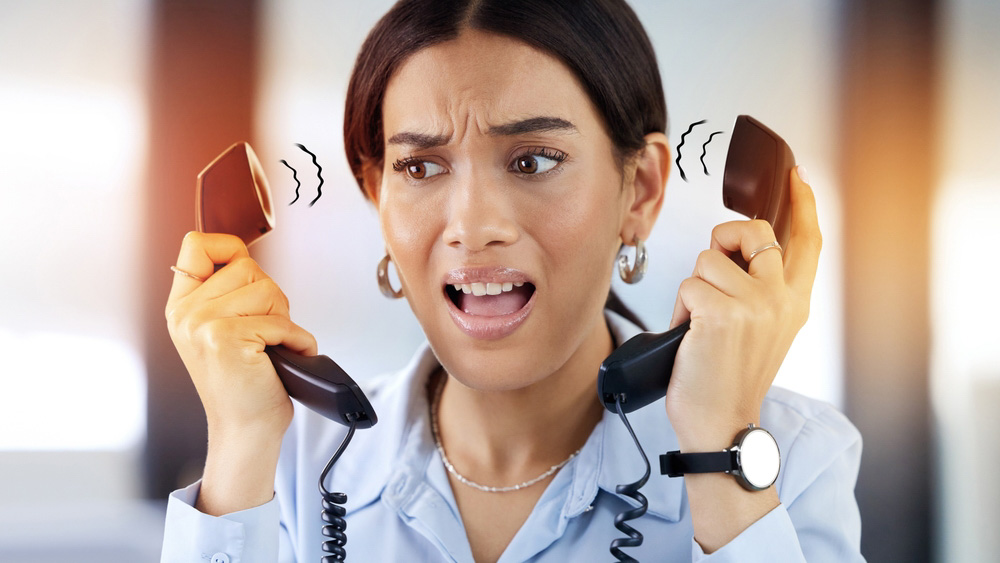 Telephone, phone call and stress of receptionist in office with anxiety, customer service or confused. Landline, overlay and secretary tension in communication for pressure, scared or problem at work